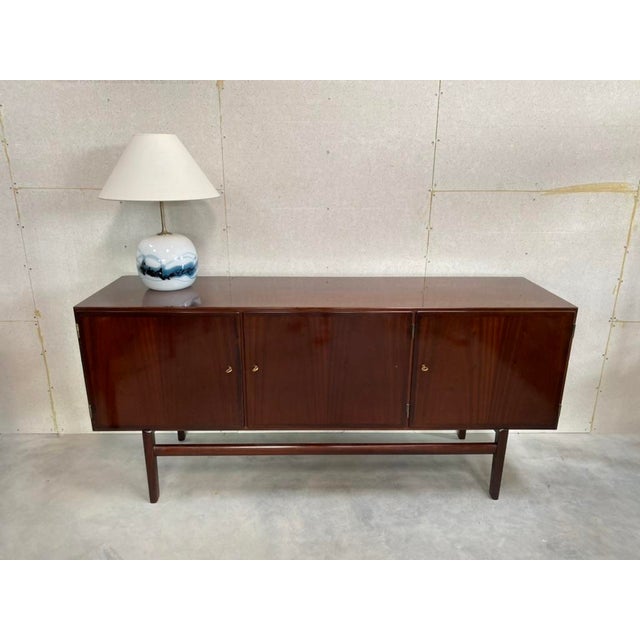 A refined example of danish modern design by ole wanscher, this three-door low cabinet is part of the celebrated...