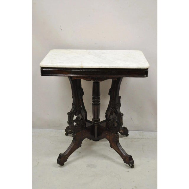 Antique Eastlake Victorian Marble Top Carved Walnut Parlor Accent Side Table. Circa Late 19th Century. Measurements: 29.5"...