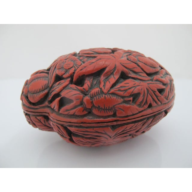 Chinese strawberry or acorn shaped trinket box with hand carved butterfly, floral, and leaf motif. Measures 4 1/4" x 3" x...