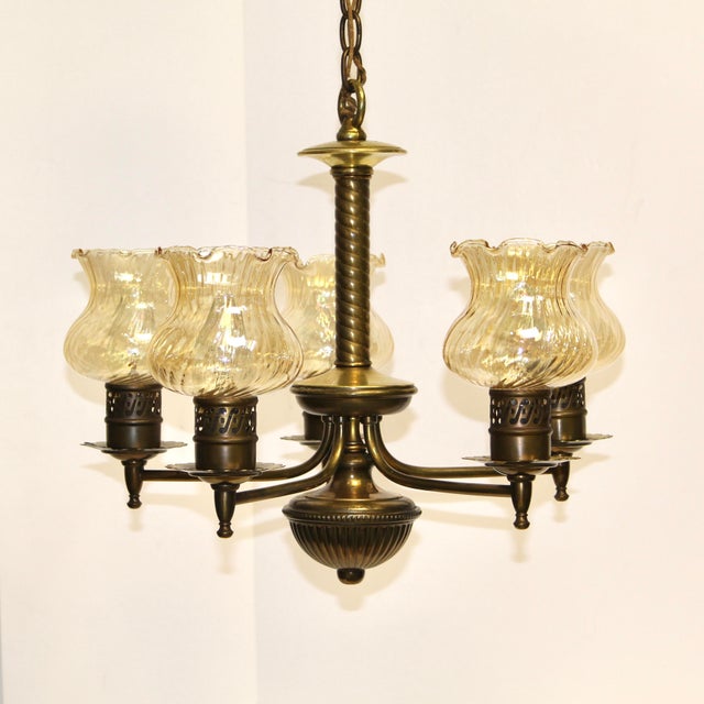 Distinctive twisted central column with 5 curved brass arms each supporting a delicate swirled glass shade. Brass...