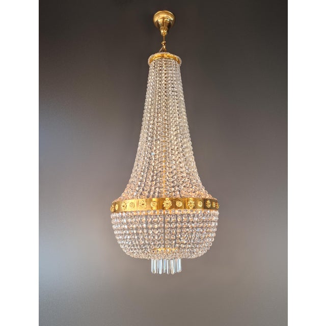 A large and exceptionally tall crystal chandelier in the classic tent-and-bag design. Numerous strands of clear, faceted...