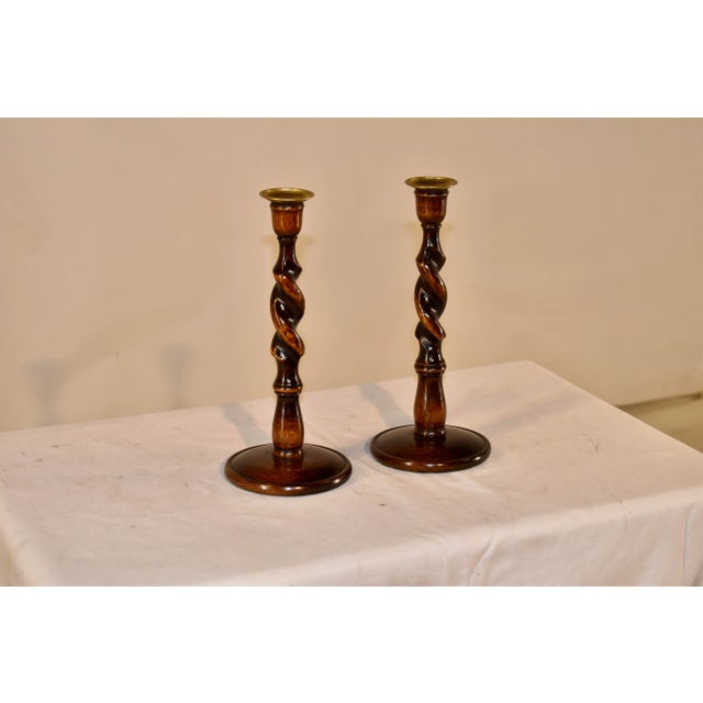 Pair of 19th century oak candlesticks from England with hand cast brass candle cups, supported on hand turned barley twist...