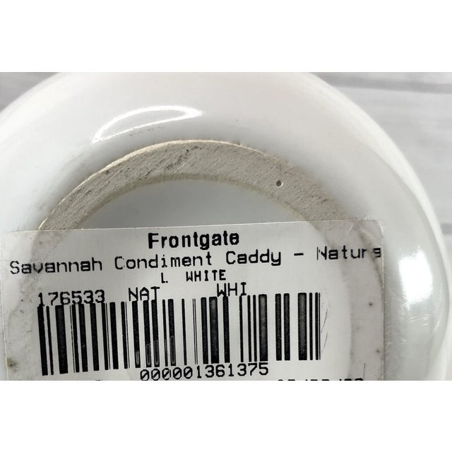 Featuring cane and brass accents, this white condiment caddy is part of the Frontgate, Inc., Savannah Serving Collection...