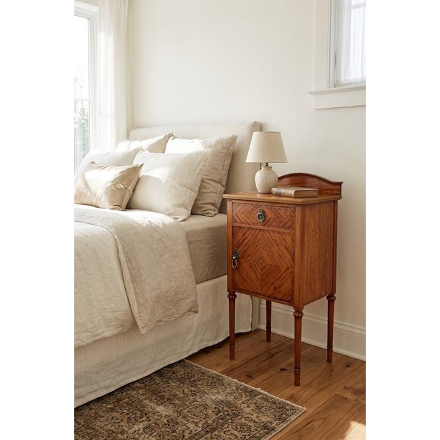 K0566 a fine quality edwardian-era bedside cabinet crafted from beautifully figured satinwood. The piece features an...