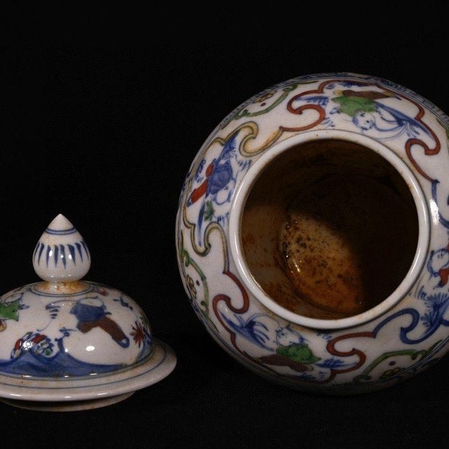 A handsome matched pair of traditional Chinese general’s lidded jars, hand painted in vibrant wucai polychrome enamel. The...