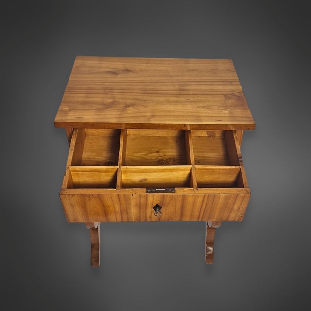Biedermeier side table with a lyre-shaped base. The two side lyres are crafted from solid cherry wood and adorned with...