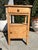 Vintage pine side table with rectangular top and integrated back ledge. Features one upper drawer, open middle shelf, and...