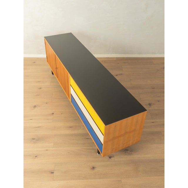 Wonderful sideboard from the 1960s. The body is finished in walnut veneer with two doors, one shelf, three Formica-coated...