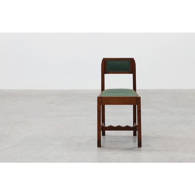 A Belgian Art Deco side chair from the 1920s, crafted in solid oak with a distinctly modernist sensibility. Its geometric,...