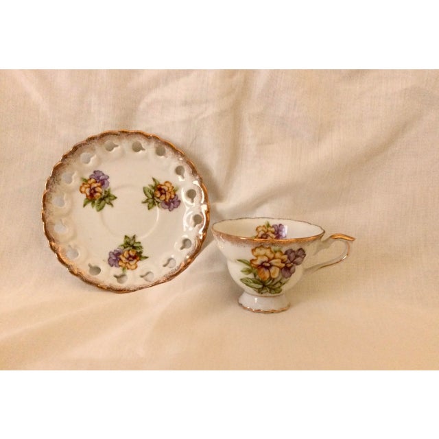 Yellow and purple pansies decorate these pretty cups and reticulated saucers, trimmed with flecks of gold. There are four...
