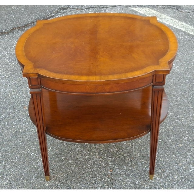 A Vintage Regency style two-tier side table with clean lines, features fluted legs, brass details on the feet (ferrules),...