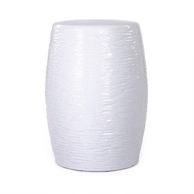 The Sinclair Garden Stool is a ceramic garden stool with a classic barrel form and an allover textured ripple pattern in a...