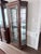 Item is marked as Thomasville (shown in 3rd photo). An elegant standalone curio cabinet with a distinctive curved glass...