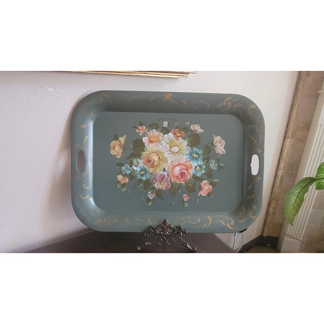 A vibrant relic of mid-century domestic charm, this hand-painted metal serving tray captures the romance of everyday...