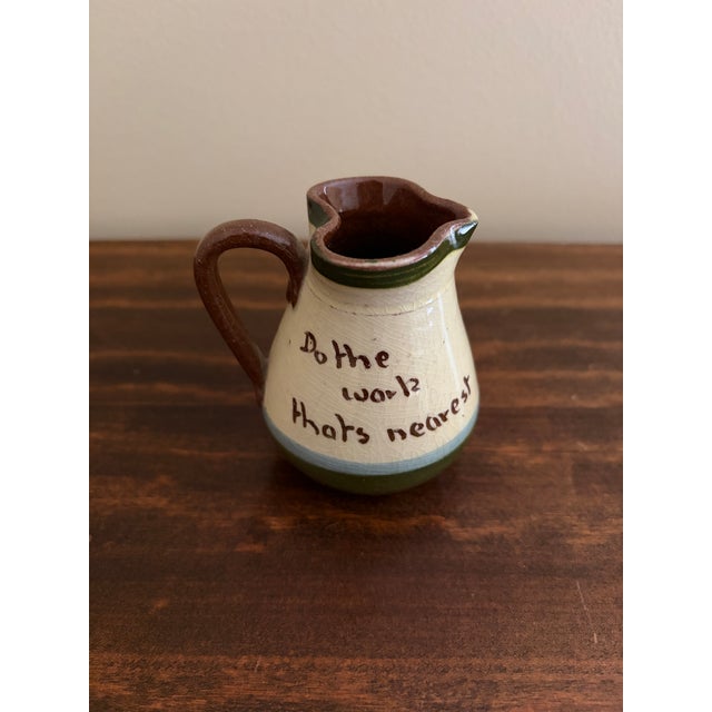 A charming English Torquay pottery pitcher from Devon, England, featuring the whimsical hand-painted phrase: “Do the work...