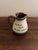 A charming English Torquay pottery pitcher from Devon, England, featuring the whimsical hand-painted phrase: “Do the work...