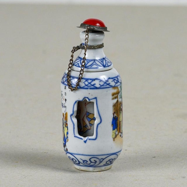 This intriguing cylindrical chinese porcelain snuff bottle, dating back to the 20th century, is a collector's item that...