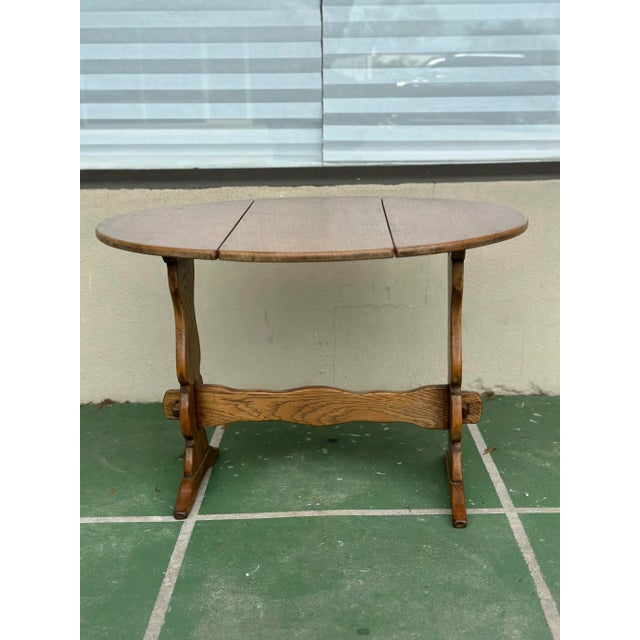 This early 20th century English oak table is a charming and practical piece, thoughtfully designed and beautifully...