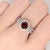 A spessartine garnet rests in a deep red at the heart of this solid 14K white gold ring, accented with earth-mined...