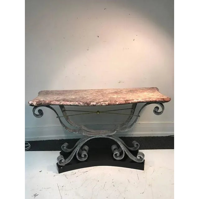 Decorative French Art Deco forged iron, and marble top console table with brass accents in the manner of Raymond Subes...