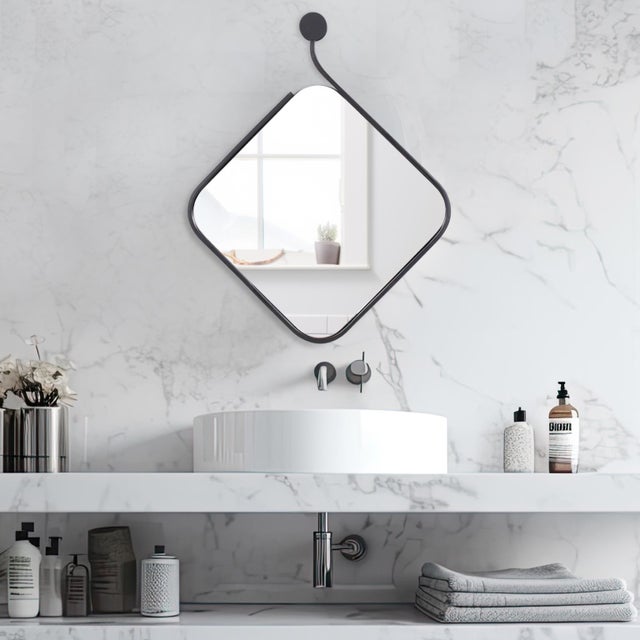 The matte black frame is crafted to appear as if it's delicately being peeled off the surface of the mirror, leaving the...