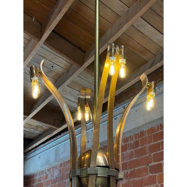 A striking Italian Mid-Century Modern chandelier, crafted entirely from solid brass and in style of Guglielmo Ulrich,...
