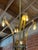 A striking Italian Mid-Century Modern chandelier, crafted entirely from solid brass and in style of Guglielmo Ulrich,...