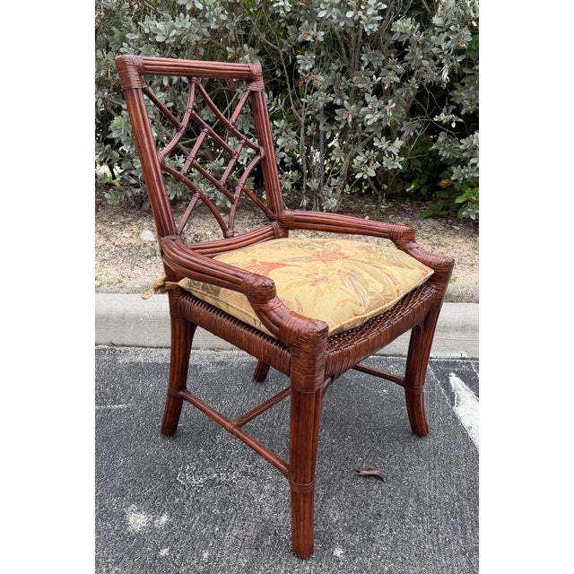 Striking vintage set of six rattan dining chairs featuring distinctive open fretwork backs, gracefully curved frames, and...