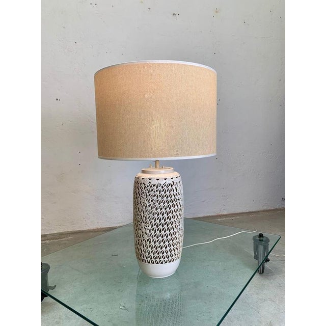Glazed ceramic table lamp and fabric shade, 1960, italy. Glazed ceramic table lamp in white, body pierced with geometric...