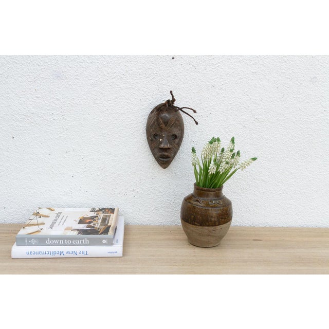 Discover the captivating allure of authentic African art with this vintage hand-carved wooden mask. Imbued with a rich...