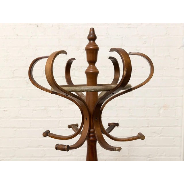 A charming vintage hall tree with a tall turned wood center post, sculptural bentwood hooks, and an integrated circular...