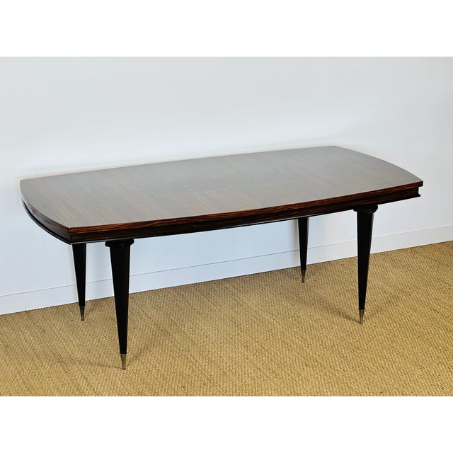A superb art deco modernist table from the 1940s, featuring an elegant top in exotic wood veneer (macassar ebony),...