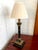 Mid 20th century black and gold Corinthian column table lamp with hand painted florals and a gold drip candle sleeve. A...