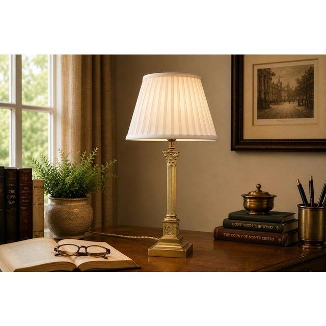 A beautifully proportioned gilded brass column table lamp of quiet architectural authority, combining the essential...