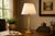 A beautifully proportioned gilded brass column table lamp of quiet architectural authority, combining the essential...