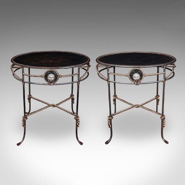 This is a pair of vintage oval garden tables. A French, cast iron and steel veranda serving table in Regency revival...