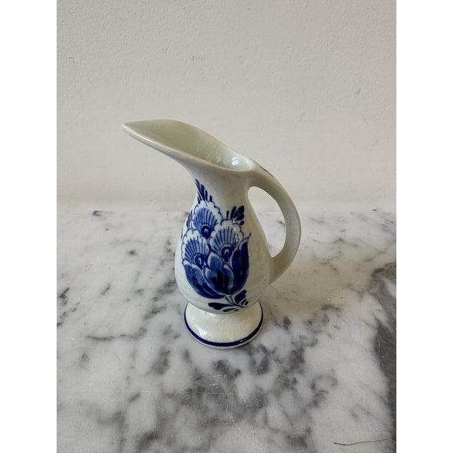 Vintage Delft Blue Holland Creamer Vase with Handle and Hand Painted Flowers. This piece of pottery is known for its...