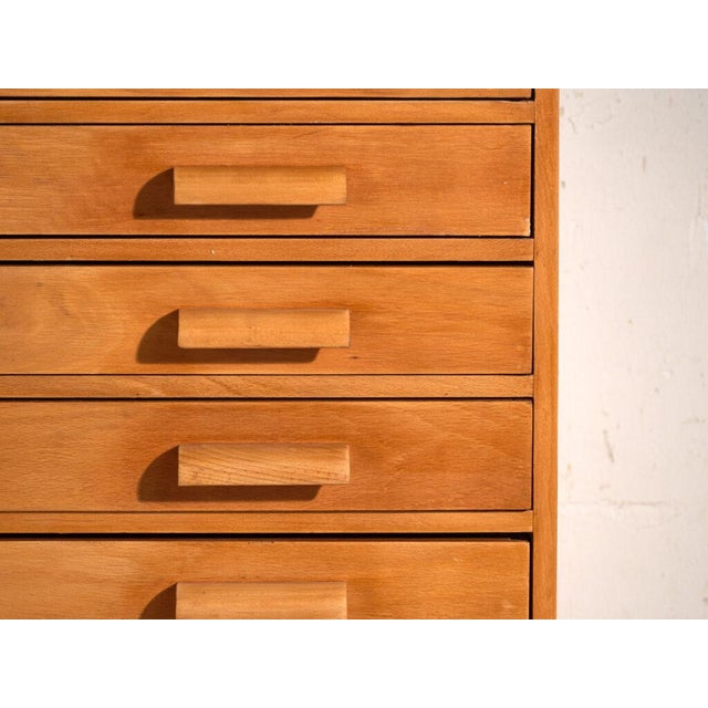 This antique plan chest in beech wood is an industrial filing cabinet with ten flat drawers and movable interior dividers....