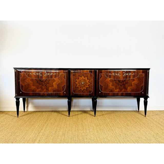 An elegant, low sideboard of French manufacture, dating from the 1950s, blending classic aesthetics with the refinement of...