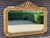 An impressive late 20th-century French Louis XVI-style wall mirror with a richly sculpted antique-gold frame, grand...