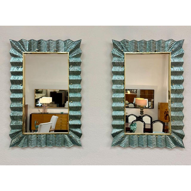 Elegant pair of decorative mirrors handcrafted in Murano, Italy, by skilled glass masters. Each mirror features a striking...