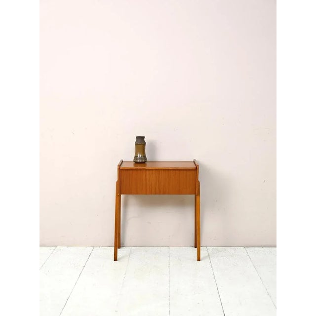 Sewing cabinet with a lifting top of Teak wood. This vintage piece of furniture can be used as a bedside table or as a...