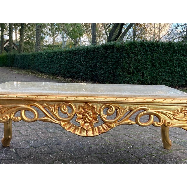 This striking 1970s Italian Baroque Revival coffee table combines elaborate hand-carved beechwood with a luminous gold...