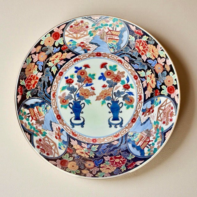 This large antique Japanese porcelain charger originates from the Arita region and is decorated in the traditional Imari...