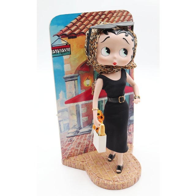 The design takes inspiration from a classic Italian cinema aesthetic, featuring a porcelain Betty Boop strolling down a...