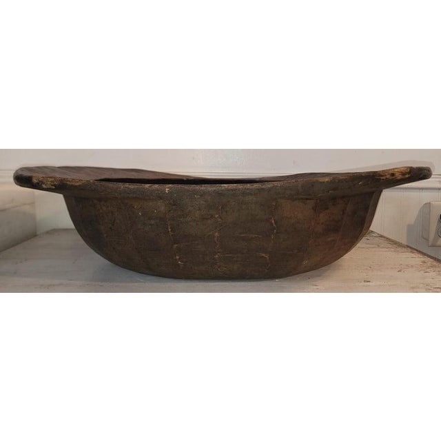 Early 19thc hand carved dough bowl with carved handles and the interior is painted black.Most unusual form and shape.
