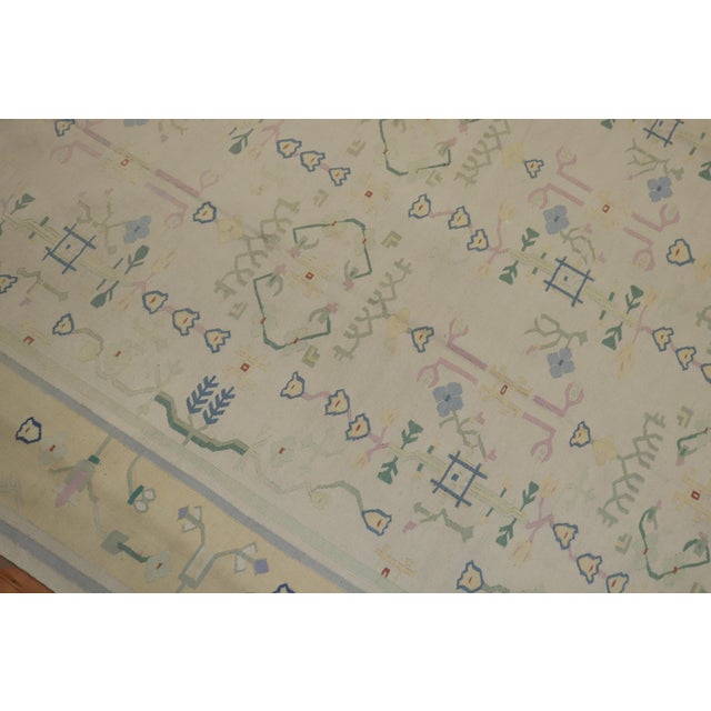 Room size Indian Dhurrie flat-weave carpet in warm pastel tones on a white field and mellow yellow border. Piece has...