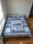 This charming handmade quilt features a vibrant nautical theme, showcasing appliquéd lighthouses, sailboats, suns, and...