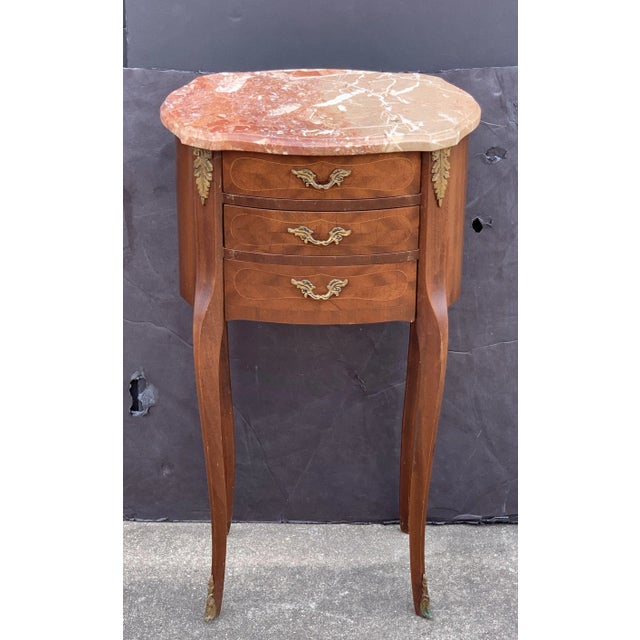 A fine pair of French bedside end tables or nightstands, each stand featuring a figured marble-top with serpentine edge...