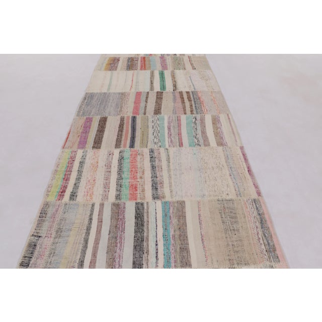 This 5x13 Turkish runner rug showcases a striking patchwork composition, handwoven in wool, combining multiple textile...